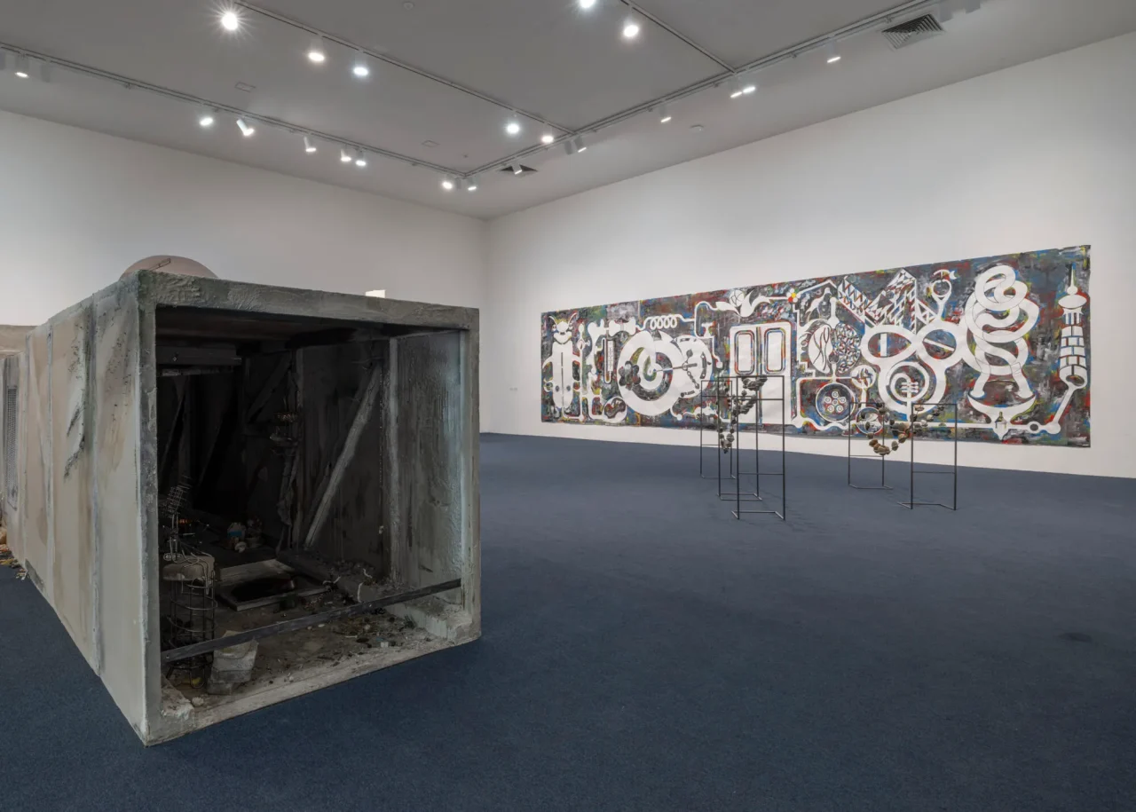 MoMA PS1「The Gatherers」展の展示風景。手前はトリア・アスタキシュヴィリのミクストメディア・インスタレーション《dark days》(2025)。奥の作品は、ジャン・カタムバイ・ムケンディの紙を支持体とした《Doors》(2023)。Photo: Courtesy MoMA PS1/Photo Kris Graves