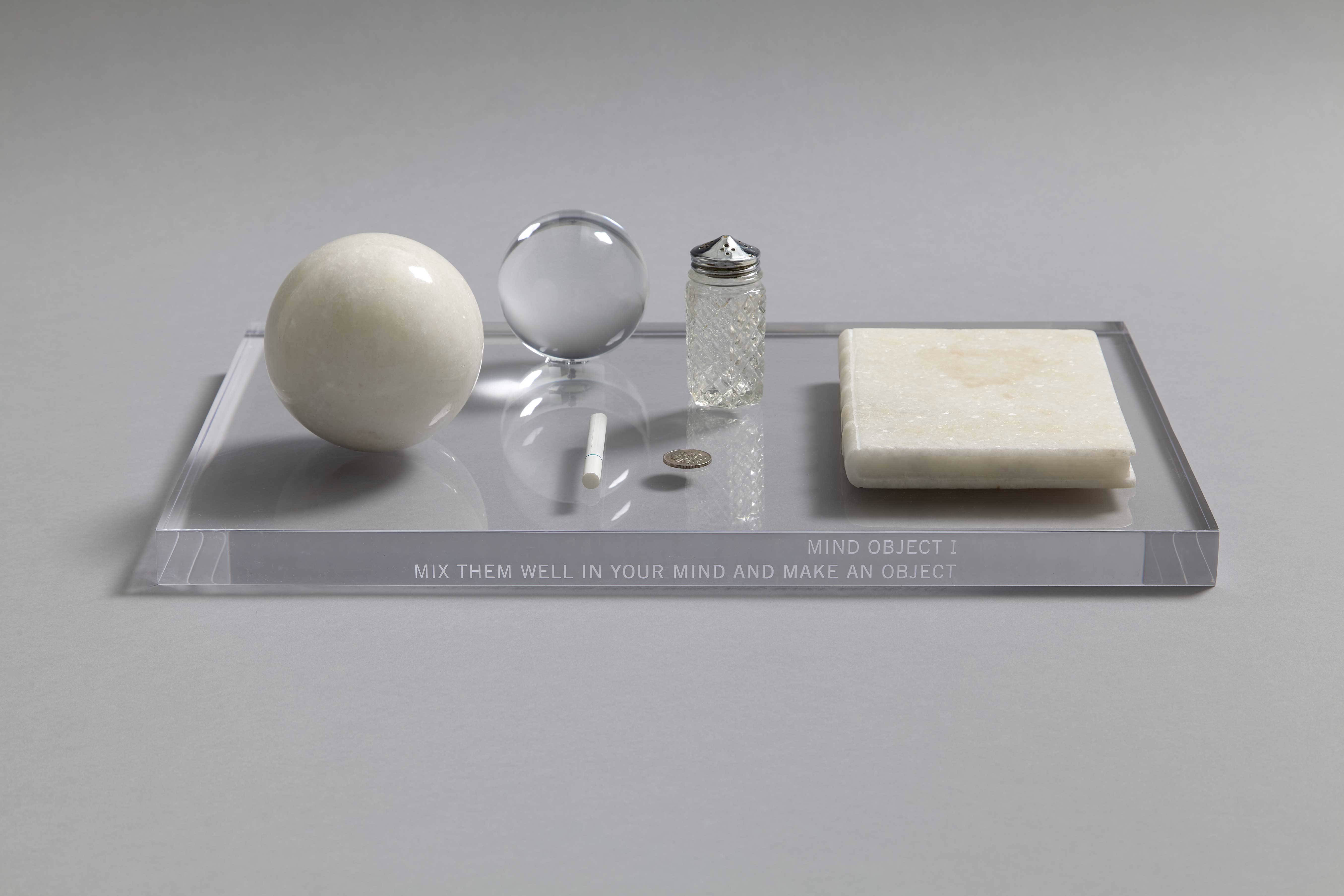 Mind Object I 1960 / 1966 Acrylic, marble, coin, cigarette, salt shaker h.2.5 x w.45.5 x d.30.0 cm ©︎ Yoko Ono